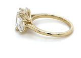 A yellow gold ring featuring a large rectangular emerald-cut diamond and baguette diamond ring in a prong setting, shown on a plain white background.