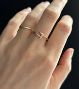 Hand wearing a rose gold ring with a diamond on a black background